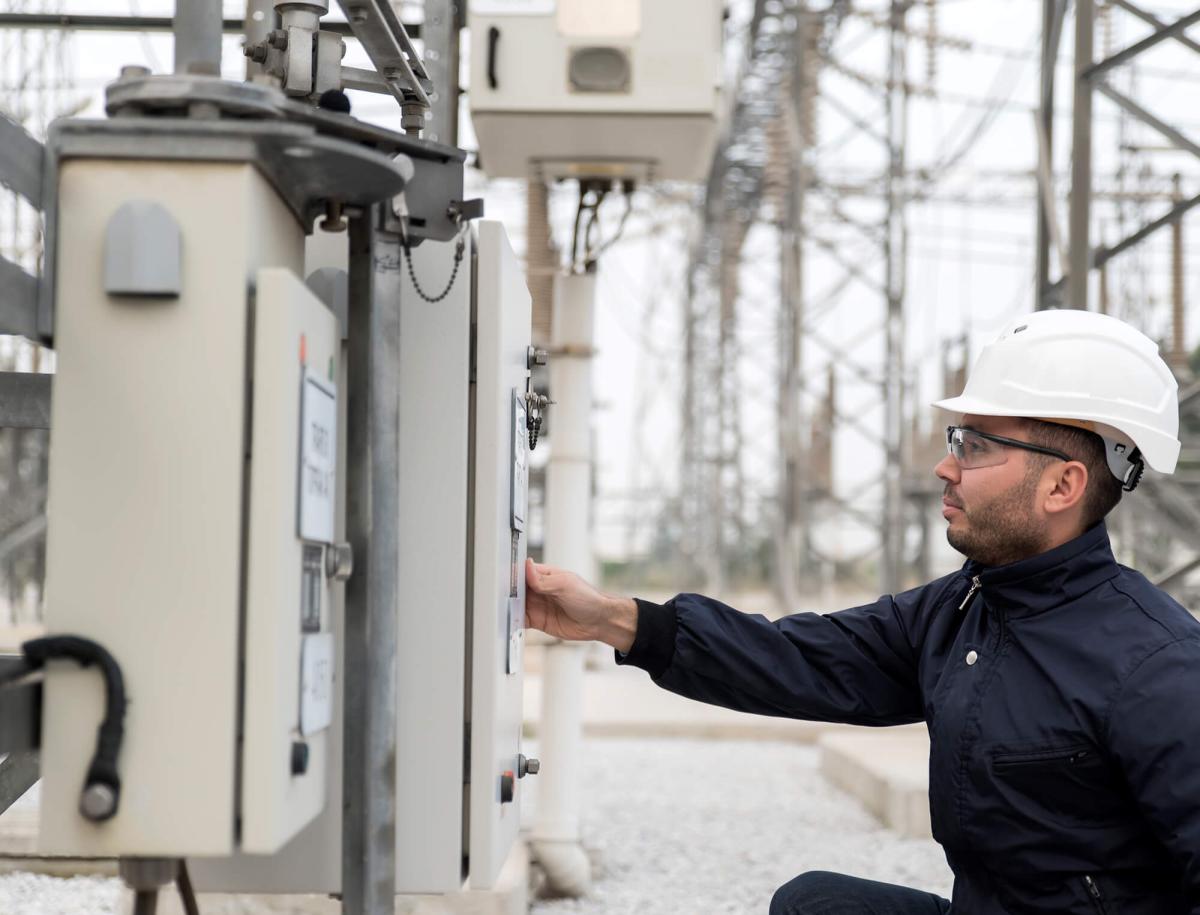 man in helmet work at electrical box